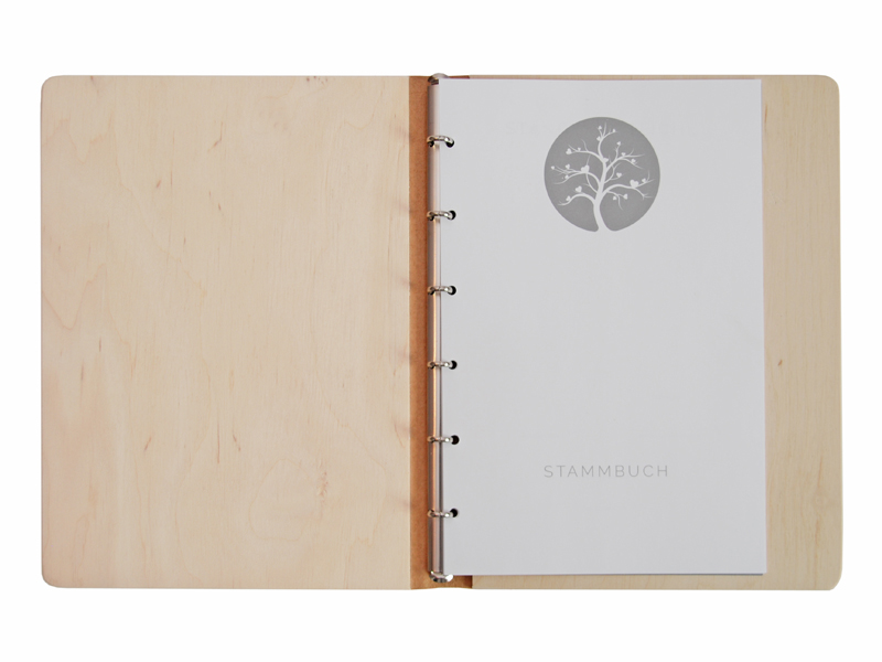 geöffnetes Holz-Stammbuch der Familie mit Einlagen