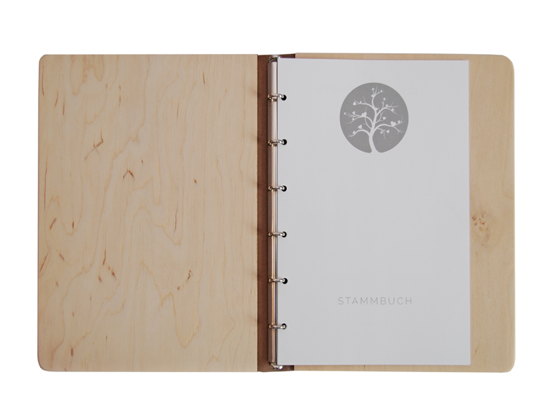 geöffnetes Holz-Stammbuch der Familie mit Einlagen